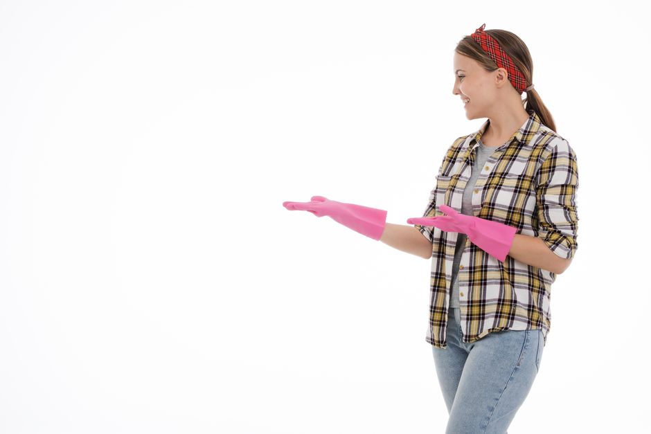 A friendly cleaning professional standing in a clean living room