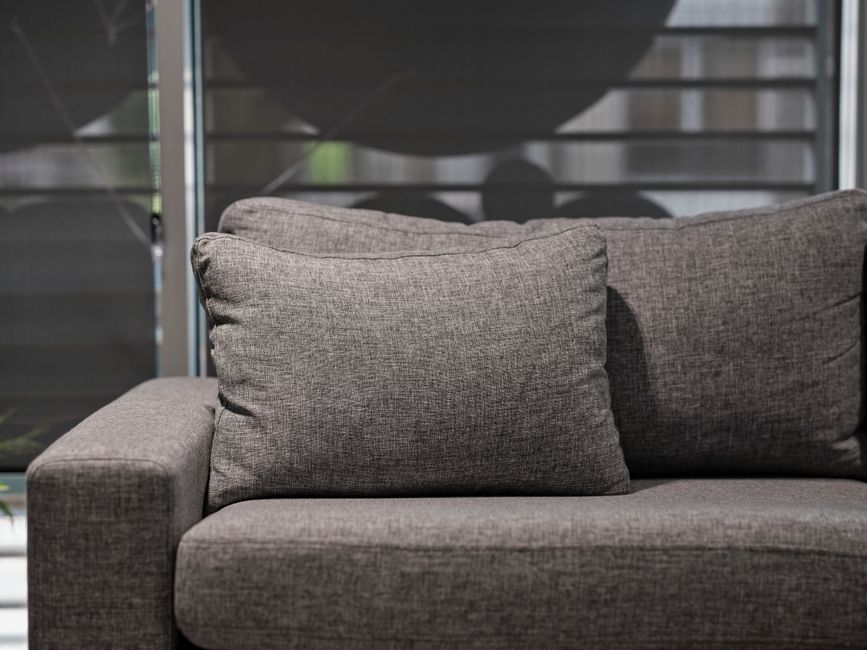 Technician performing upholstery cleaning on a sofa